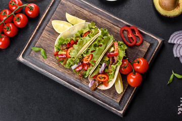 Mexican tacos with beef, tomatoes, avocado, onion and salsa sauce