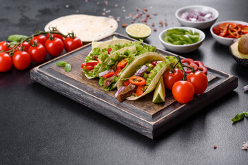 Mexican tacos with beef, tomatoes, avocado, onion and salsa sauce