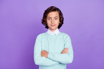 Photo of small nice brunet boy crossed arms wear blue sweater isolated on purple background