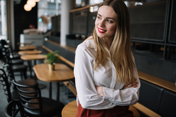 Positive young lady standing in cafe
