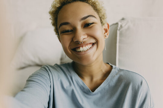 Young hispanic woman streaming online via video on smartphone. Smiling latino american blogger recording vlog for followers. Social media influencer, technology, pure happiness emotion concept
