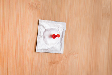 A Joke on Colleagues, Freebie or a Defective Condom - Packaged Latex Condom Pinned to a Wooden...