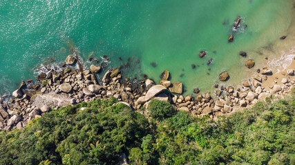 Aerial view of waves hitting rocks on a Brazilian beach coast. Balneario Camboriu
