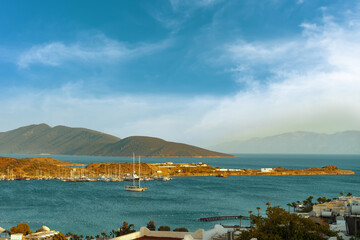 View of the bay of Bodrum, Turkey with yacht and mountains in a beautiful sunny day with cloudy blue sky. Summer landscape