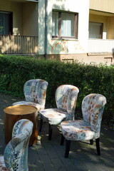 Aufgereihte wild gemusterte Sessel im Sommer bei Sonnenschein vor einem Bistro im Ostend von...