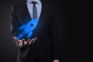 Start up concept with businessman holding abstract digital rocket icon rocket is launching and soar...