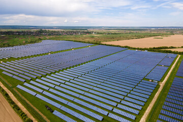 Aerial view of big sustainable electric power plant with many rows of solar photovoltaic panels for producing clean ecological electrical energy. Renewable electricity with zero emission concept.