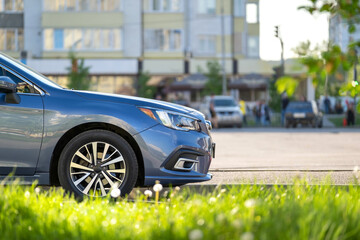 Car parked on a city street side with blurred urban traffic.