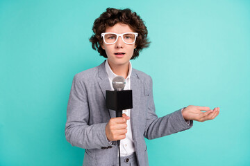 Photo of impressed shocked school boy wear grey jacket spectacles tacking interview isolated turquoise color background