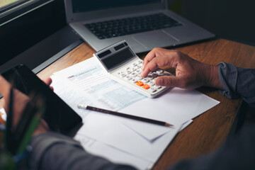 Budget and Tax planning concept, Hand's Accountant is calculating company annual tax and using...