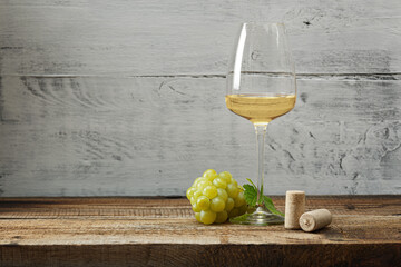 Glass of white wine on vintage wooden table - 447520263