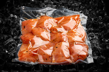 Vacuum-packed meat, on dark ice background, chicken fillet. Semifinished.