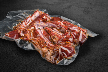 Vacuum-packed meat, on dark stone background, rack of lamb. Semifinished.