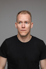 Obraz premium portrait of caucasian man in black t-shirt looks to the left isolated on grey background