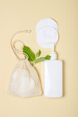 Cotton reusable makeup remover pads in a cloth bag on a beige background. The concept of ecology and conscious consumption. Reusable cotton pads