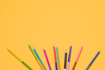 Colour school pencils on colour background copyspace