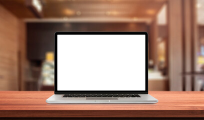 Laptop or notebook with blank screen on wood table in blurry background with fast food restaurant or coffee shop ,nature orange bokeh and sunlight in morning.
