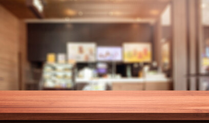 Fototapeta na wymiar wood table in blurry background with fast food restaurant or coffee shop ,nature orange bokeh and sunlight in morning.