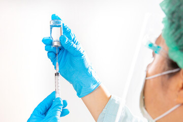 A needle and a vaccination bottle in the doctor's hand.