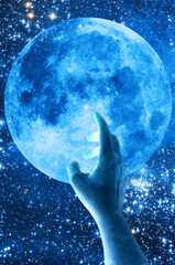 woman hand touching a full moon, mystical concept