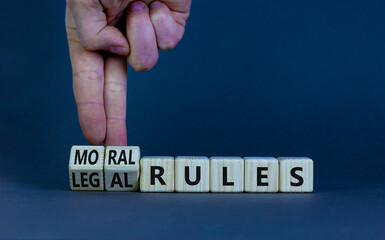 Legal or moral rules symbol. Businessman turns wooden cubes and changes words 'legal rules' to...