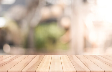 Empty wooden table top with lights bokeh on blur restaurant background.