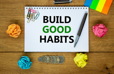 Build good habits symbol. Words 'Build good habits' on white note. Wooden table, colored paper,...