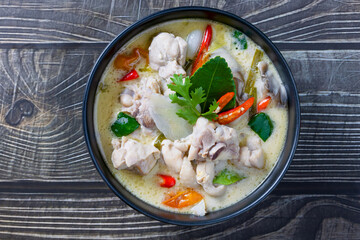 chicken coconut soup.Thai food. Tom Kha Gai in a black bowl, placed on a wooden table, popular Thai food concept.