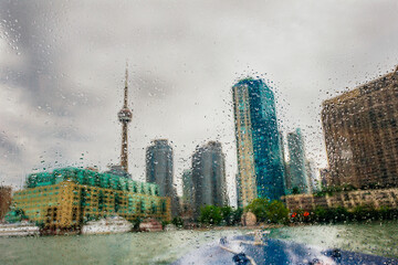 View of Toronto and the CN Tower on a rainy day from a boat window on the waterfront. Toronto, Ontario, Canada, North America, USA. - Powered by Adobe