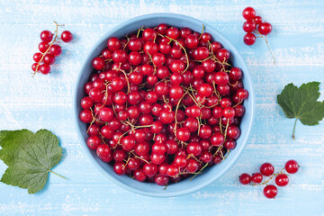 Fresh red currant in wooden bowl on dark table