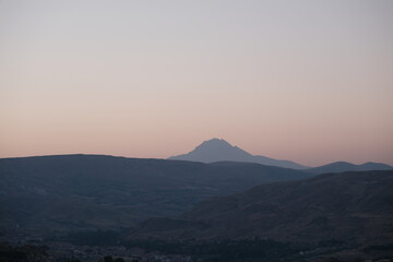 Mountain peak of Erciyes by taking photo from chimneys of Three beauties (uc guzeller) in Cappadocia early in the morning during sun rise