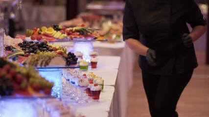 Pastry chef puts dessert on the table for a big event