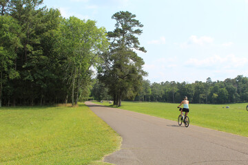 Woman riding a bicycle at the Chickamauga Civil War battlefield in Georgia during summer