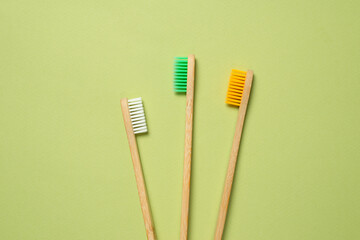 Bamboo toothbrush on a green background.