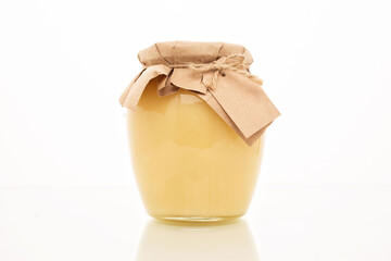 A glass jar full of sweet honey with a place for your text, isolated on a white background.