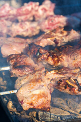 Meat on skewers is fried on coals with smoke