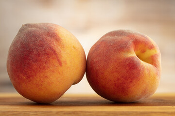 Fototapeta na wymiar Two peaches on a wooden board.