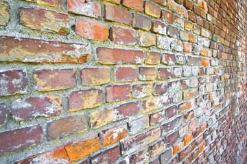 Old weathered italian brick wall with damaged bricks - perspective view
