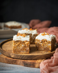Carrot cake with butter cream on a wooden table. Cake with cream cheese on a wooden plate in rustic style