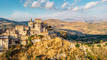 Fototapeta na wymiar Aerial view of medieval stone village,the highest village in Madonie mountain range,Sicily,Italy.Church of Santa Maria di Loreto at sunset.Picturesque stone houses,narrow cobbled streets,views of town