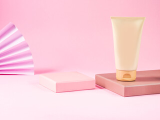 Geometric podium displays body care generic cream tube on pink background.