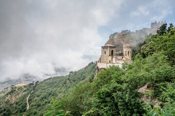 Fototapeta premium Erice,Sicily,Italy.Historic town on the top of mountains overlooking beautiful lush countryside.View of Venus Castle,Castello di Venere, in clouds.Breathtaking panorama.Misty landscape copy space