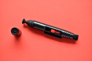 Brush for cleaning optics on a red background
