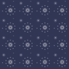 Seamless winter Christmas pattern made of white and snowflakes on a blue background.