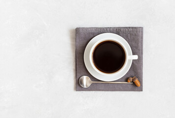 Black hot coffee in a cup on a white concrete background. Acorn coffee. Copy space, top view