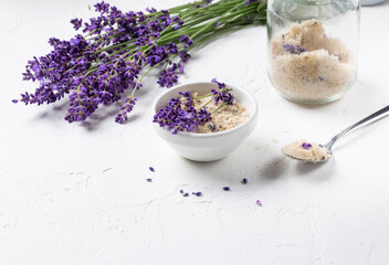 Obraz na płótnie Canvas Lavender infused sugar. Flower sugar with fresh lavender in white bowl on white background.
