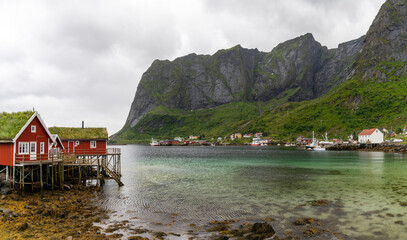 Fototapeta na wymiar colorful red wooden houses on stilts in the fjord in Moskenes in the Lofoten Islands of Norway