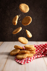 Creative image of homemade butter cookies falling on white wooden rustic table