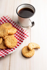 Homemade crunchy cookies and a coffee cup on wooden white rustic table