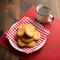 Homemade crunchy cookies and a coffee cup on wooden rustic table